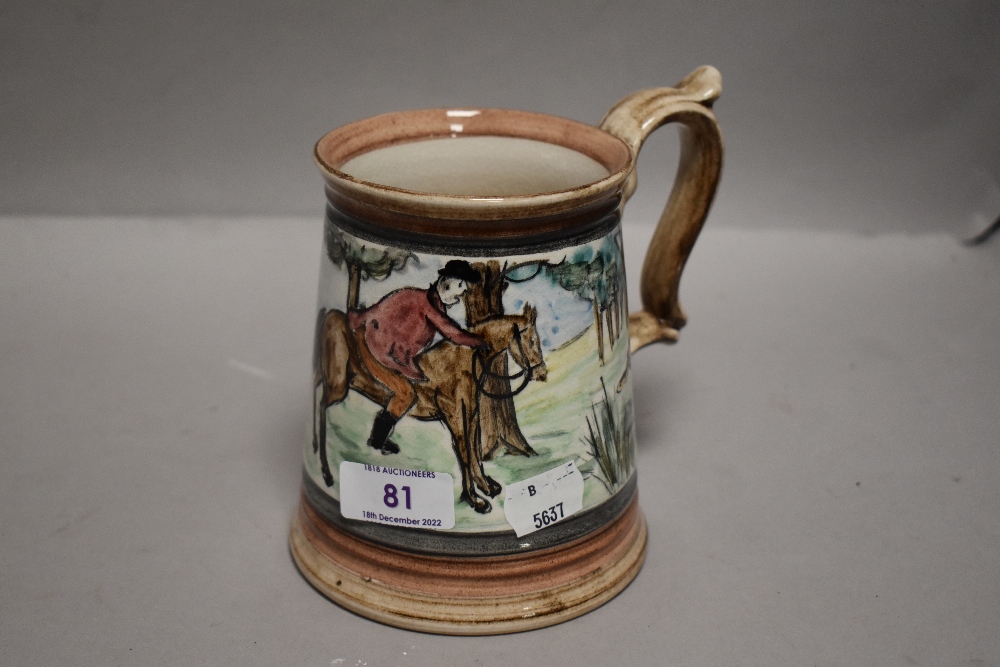 A large ceramic tankard hand decorated with a fox hunting scene