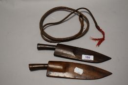 Two early 20th century small sized Kukri knives in wooden sheaths with a small whip