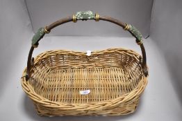 A hand woven wicker basket having a bent wood handle with glass decoration