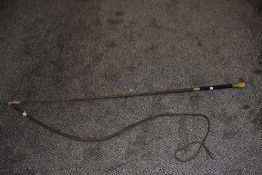 A traditional horse whip with horn handle