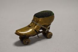 An early 20th century novelty pin cushion in the form of a Roller Skate with brass case and rotating