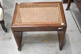 An Art Deco oak stool having canework seat