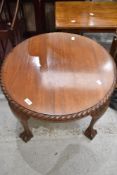 An early 20th Century mahogany circular coffee table having gadrooned edge and ball and claw feet