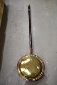 A traditional brass and copper bed warming pan