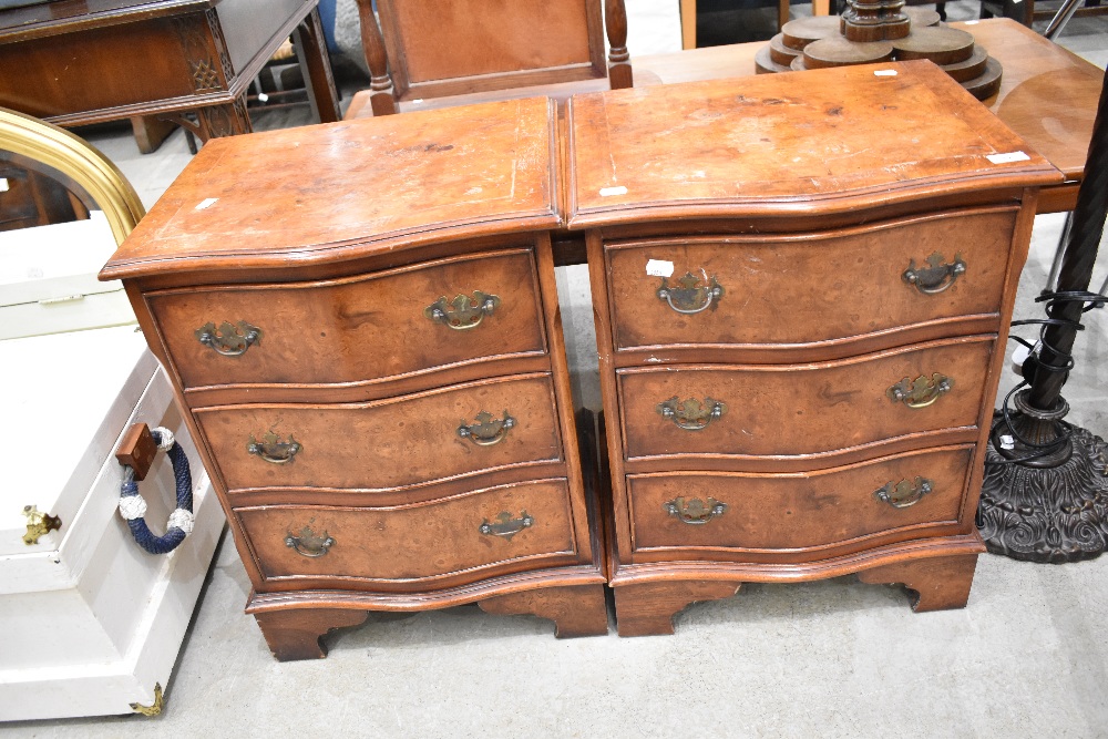 A pair of reproduction Regency walnut serpentine front bedside chests