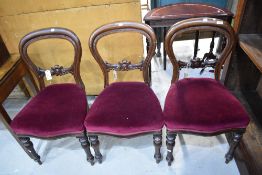 Three Victorian balloon back dining chairs with carved details and turned legs