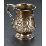 A Victorian silver tankard of baluster form having repousse floral and scroll decoratio, moulded