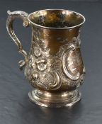 A Victorian silver tankard of baluster form having repousse floral and scroll decoratio, moulded