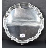 A silver salver of plain form having shaped pie crust rim and trefoil shell feet, Sheffield 1972,