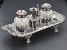 A silver plated ink stand, of oblong form with gadrooned and foliate embossed rim enclosing the