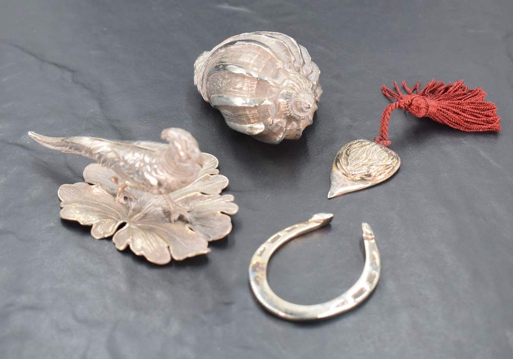 Four HM silver and white metal trinkets including lucky horseshoe, pheasant study, conche shell