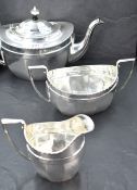 A three piece silver tea set of tapered oval form having pressed decoration to rim, Chester 1921,