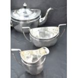 A three piece silver tea set of tapered oval form having pressed decoration to rim, Chester 1921,