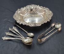 A silver trinket dish having repousse scroll and chequered decoration with plain cartouche, London