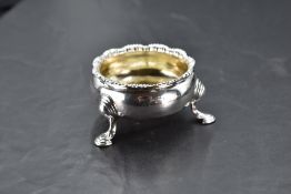 A George II silver salt, of circular form with shaped and moulded edge detail and three down swept