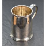 A silver tankard of plain form having moulded handle, reided decoration to lip and foot and engraved