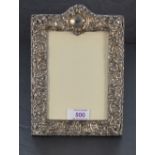 An Victorian silver photograph frame having extensive cut decoration, plain cartouche and blue