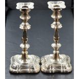 A pair of early 20th Century silver candlesticks of shaped form having removable sconces, shaped