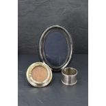 An modern oval silver photograph with black velvet easel back, a small circular silver photo frame