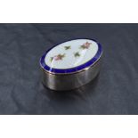 An early 20th Century silver trinket box of plain oval form having enamelled lid with rose