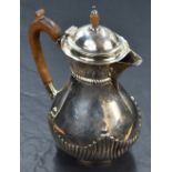 A Victorian silver hot water pot of baluster form having gadrooned decoration, engraved