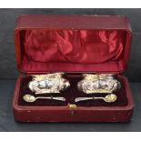 A cased set of Edwardian silver salts, of shaped rectangular form and embossed with foliate scrolls,