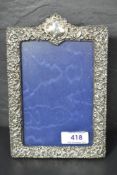 An Edwardian silver photograph frame having extensive cut decoration, plain cartouche and blue