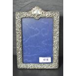 An Edwardian silver photograph frame having extensive cut decoration, plain cartouche and blue