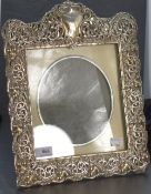 A large Edwardian silver photograph frame having extensive cut decoration, plain cartouche and