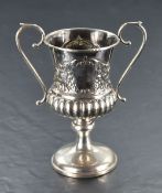 A silver loving cup having loop handles, plain cartouches and gadrooned decoration with pedestal