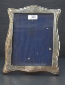An early 20th Century silver photograph frame of plain shaped form having wooden easel back,