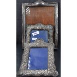 A group of three silver mounted photograph frames, two extensively moulded with C-scrolls, the other