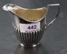 An Edwardian silver cream jug, of half fluted helmet form, marks for London 1905, maker William