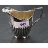 An Edwardian silver cream jug, of half fluted helmet form, marks for London 1905, maker William