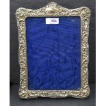 An Edwardian silver photograph frame having extensive cut decoration, plain cartouche and purple