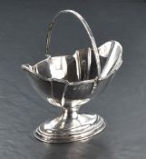 An early 20th Century swing handled sugar bowl having plain fluted decoration to oval pedestal foot,