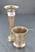 An HM silver stem vase of short trumpet form having repousse floral decoration with weighted base,