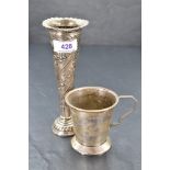 An HM silver stem vase of short trumpet form having repousse floral decoration with weighted base,