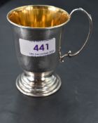 An Elizabeth II silver christening mug, with scrolled loop handle, gilt interior and stepped