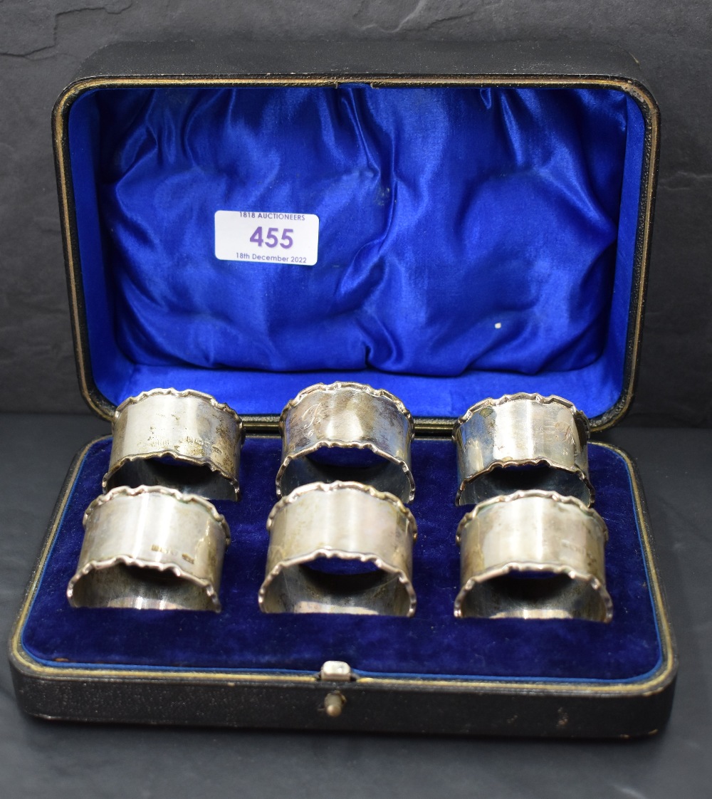 A cased set of six George V silver napkin rings, of circular form with moulded edge detail, engraved