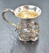 A Victorian Christening tankard having repousse floral decoration, plain cartouche and moulded