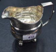 A Georgian silver cream jug of plain form having bun feet and archictural handle, Newcastle 1815,