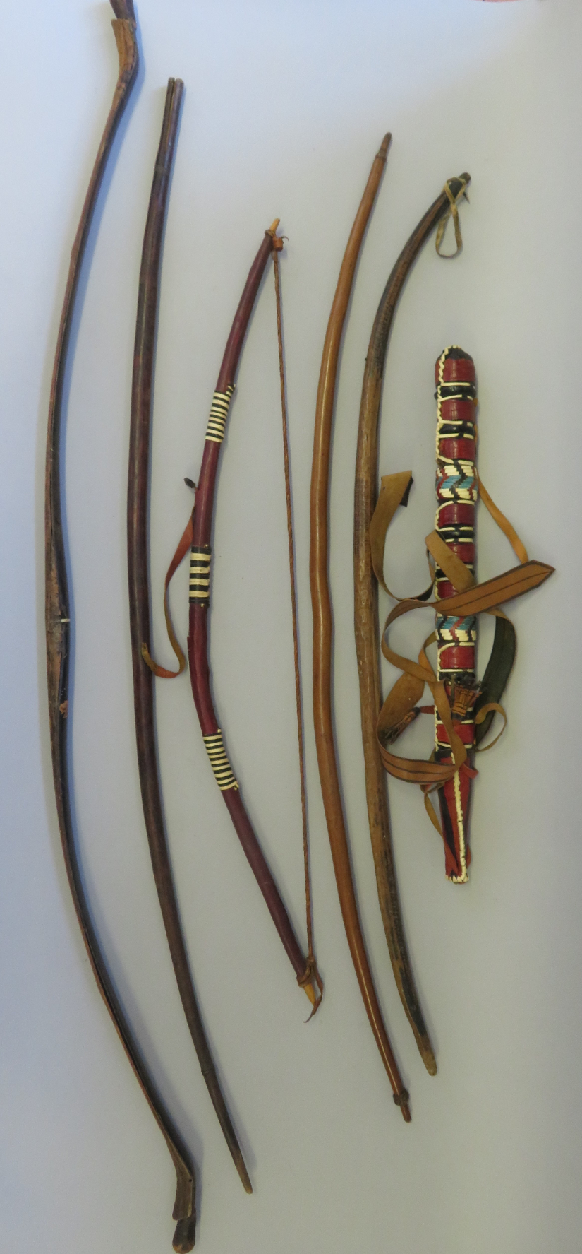 FOUR AFRICAN BOWS, A FURTHER BOW, AN AFRICAN QUIVER AND THREE ARROWS