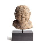 A MAJAPAHIT TUFFSTONE BUST OF A BOY