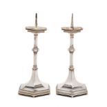A PAIR OF GEORGE V ARTS AND CRAFTS SILVER PRICKET CANDLESTICKS