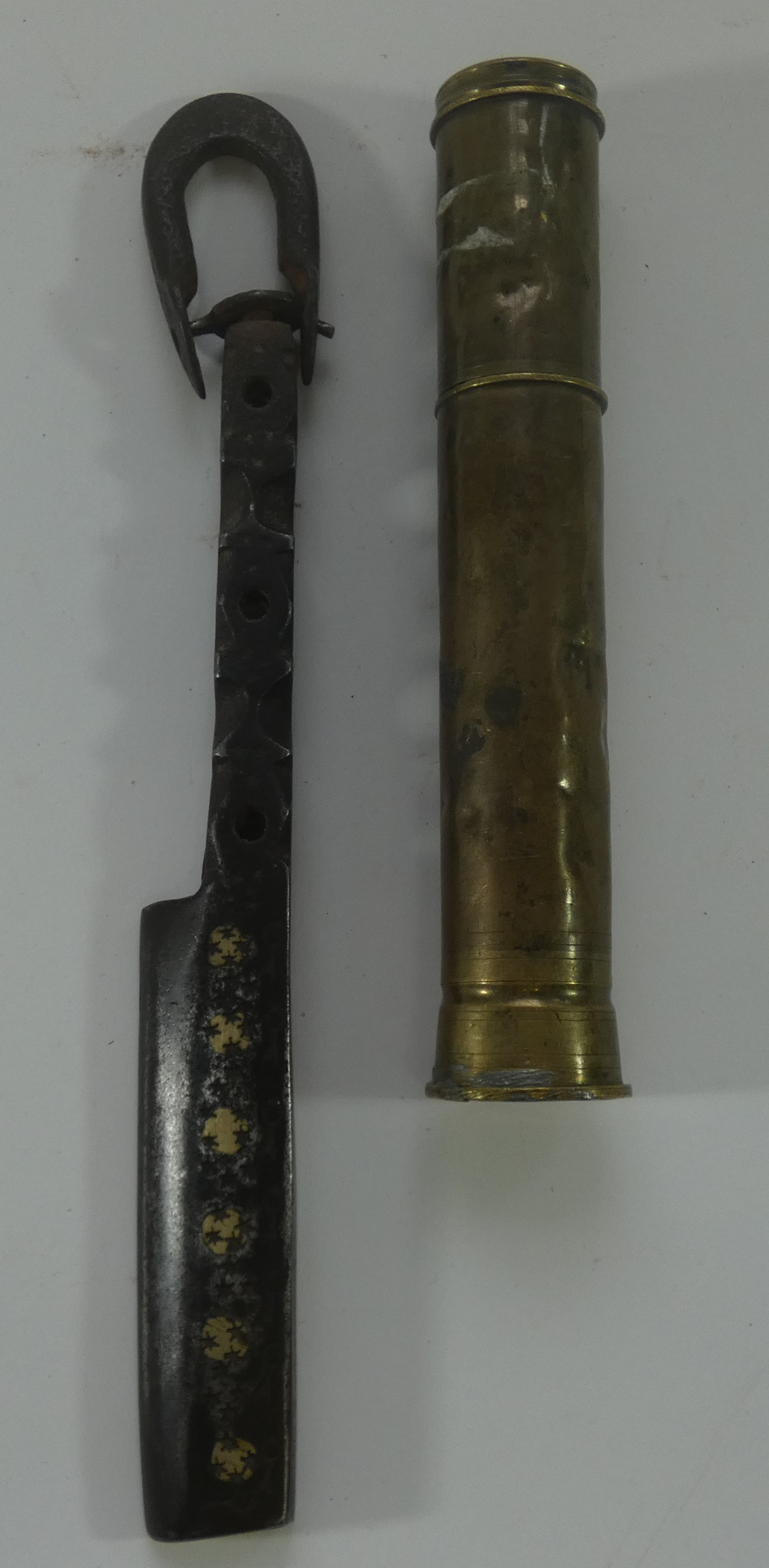 AN INDIAN IRON TOOL AND A BRASS CANNISTER