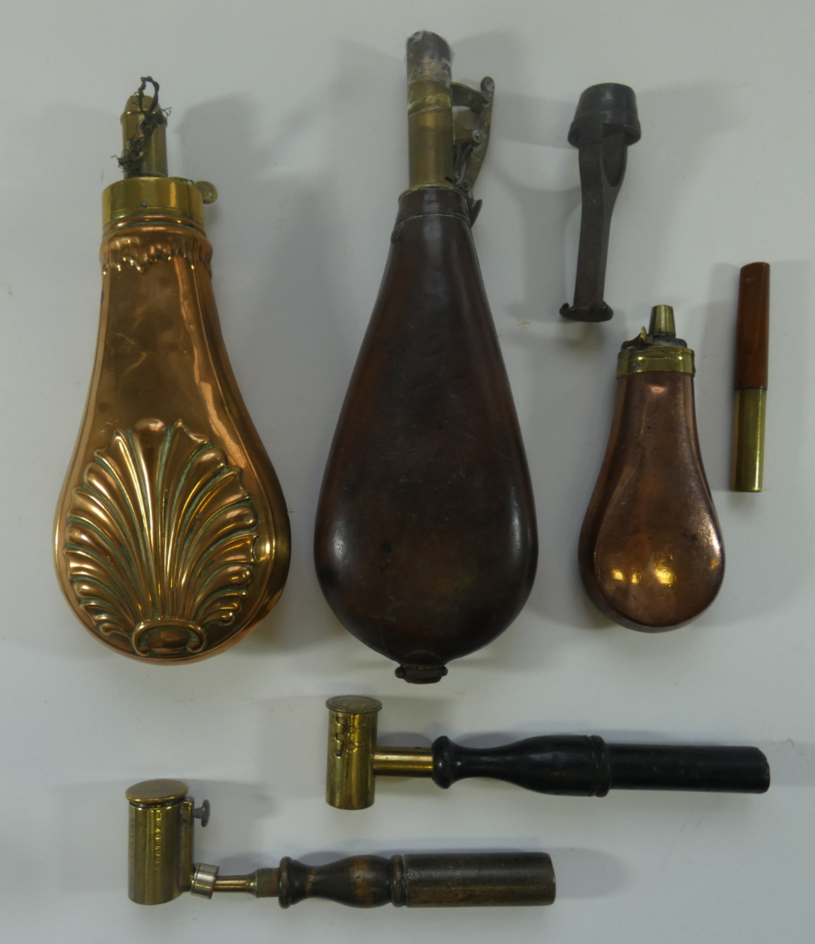 AN EMBOSSED BRASS POWDER-FLASK; A COPPER PISTOL FLASK; A LEATHER SHOT-FLASK; TWO POWDER MEASURES AND