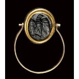 A roman dark glass paste intaglio set in a gold swivel ring. Eagle.1st - 3rd century A.D.