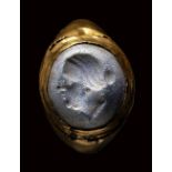 A greek Hellenistic gold ring set with a glass intaglio. Female portrait.2nd - 1st century