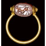 An etruscan carnelian scarab set in a gold swivel ring. Centaur. 4th century B.C.
